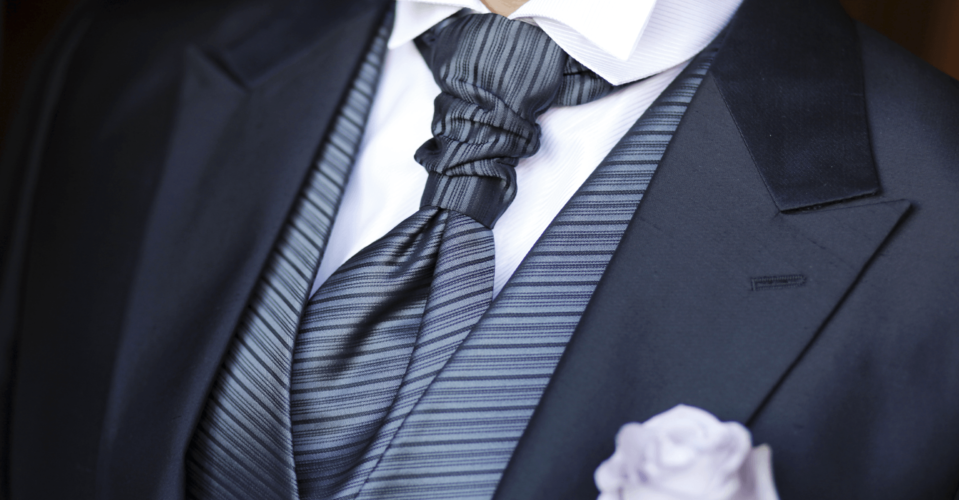 Un uomo in giacca e cravatta con fazzoletto da taschino