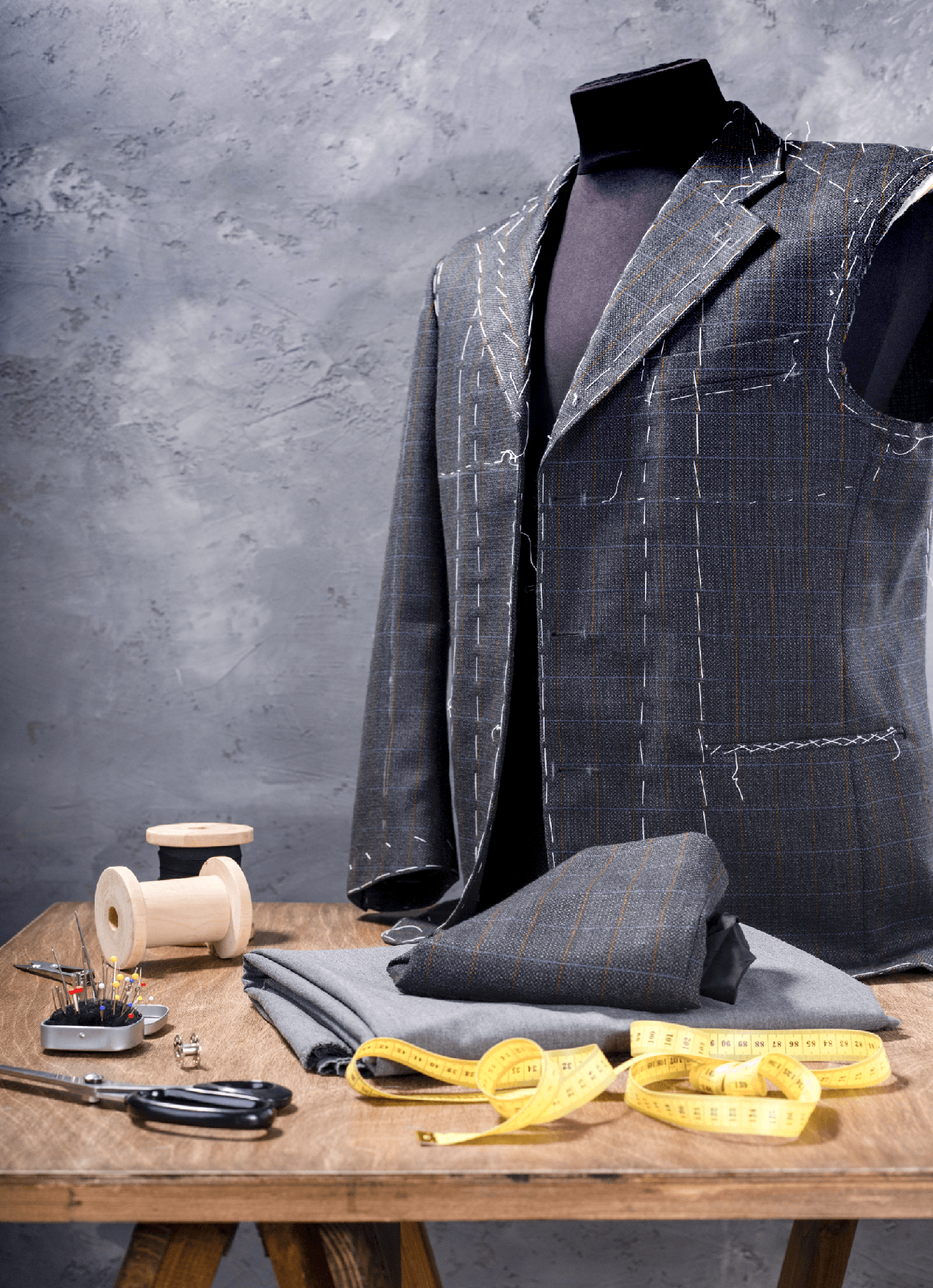 Un abito viene confezionato su un manichino su un tavolo di legno.