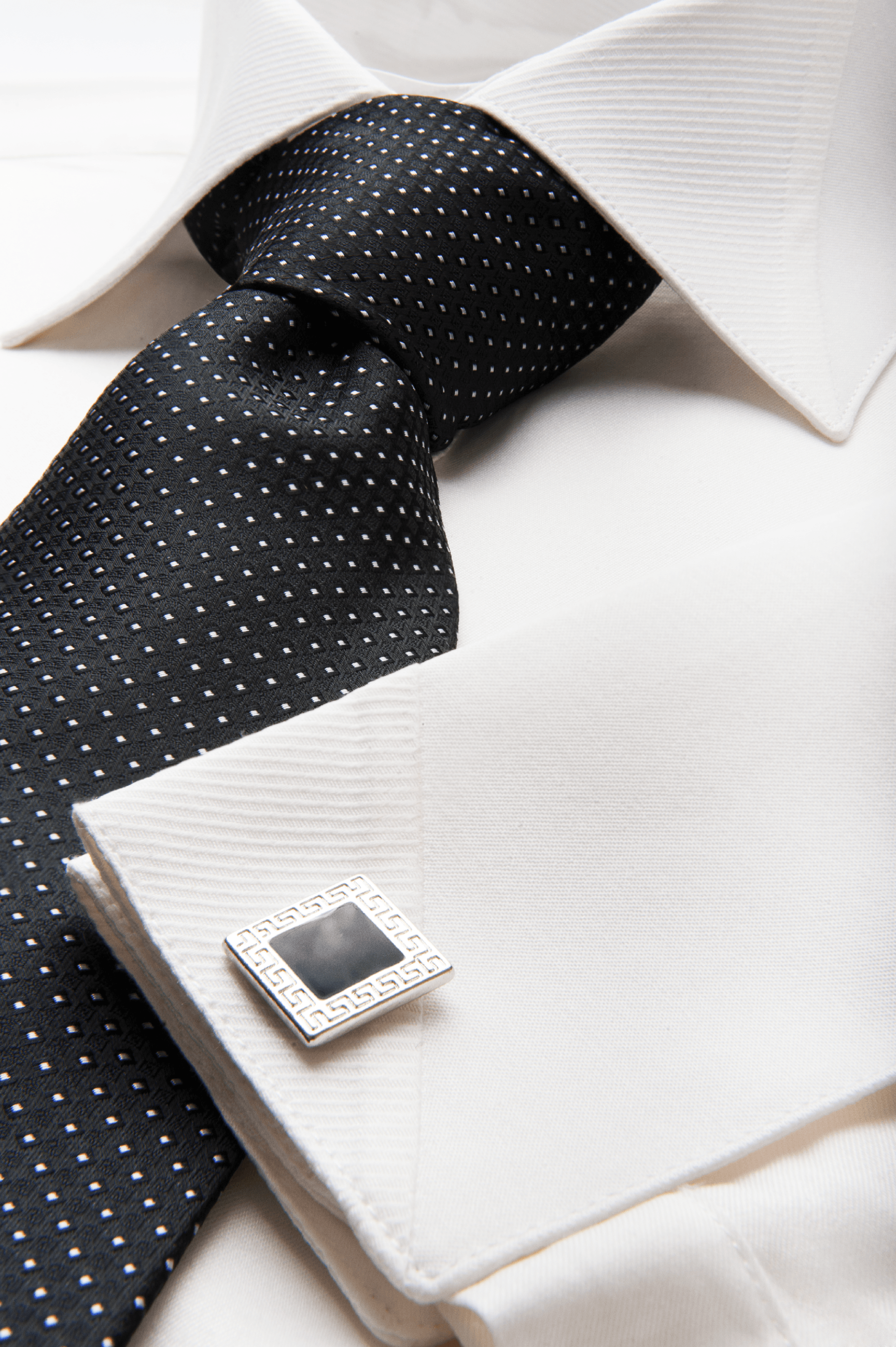 Una camicia bianca con cravatta nera e gemelli