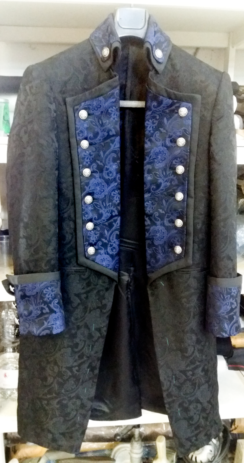 Una giacca nera e blu è appesa a una gruccia.