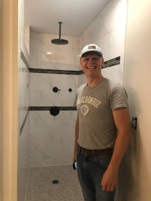 A man and two women are standing next to each other holding cleaning supplies.