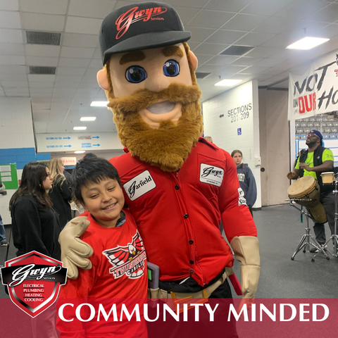 A mascot with a beard is posing for a picture with a young boy