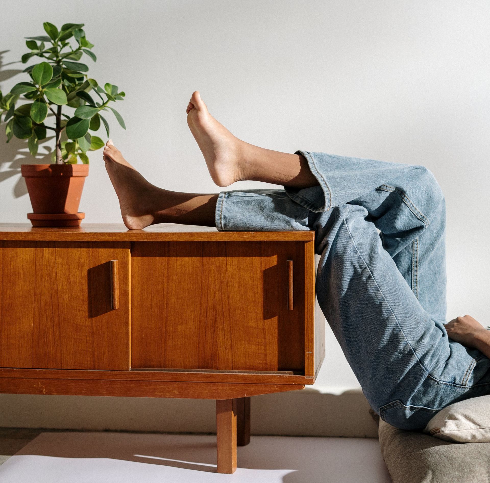 A person laying on a couch with their feet on a wooden table