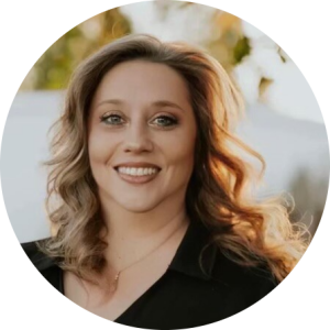 A woman in a black shirt is smiling for the camera.