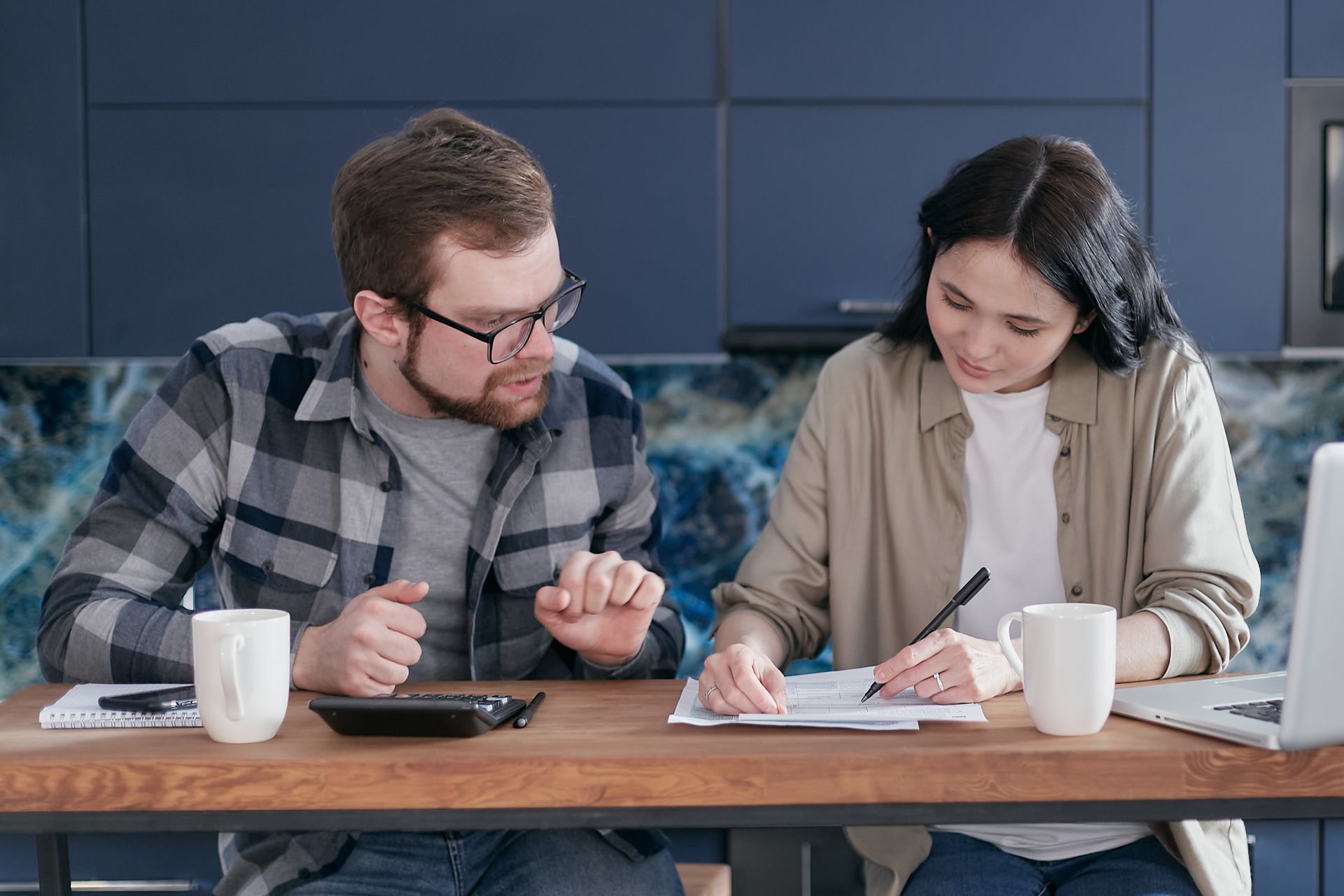 Image of a man and a woman performing tax calculation and strategic planning