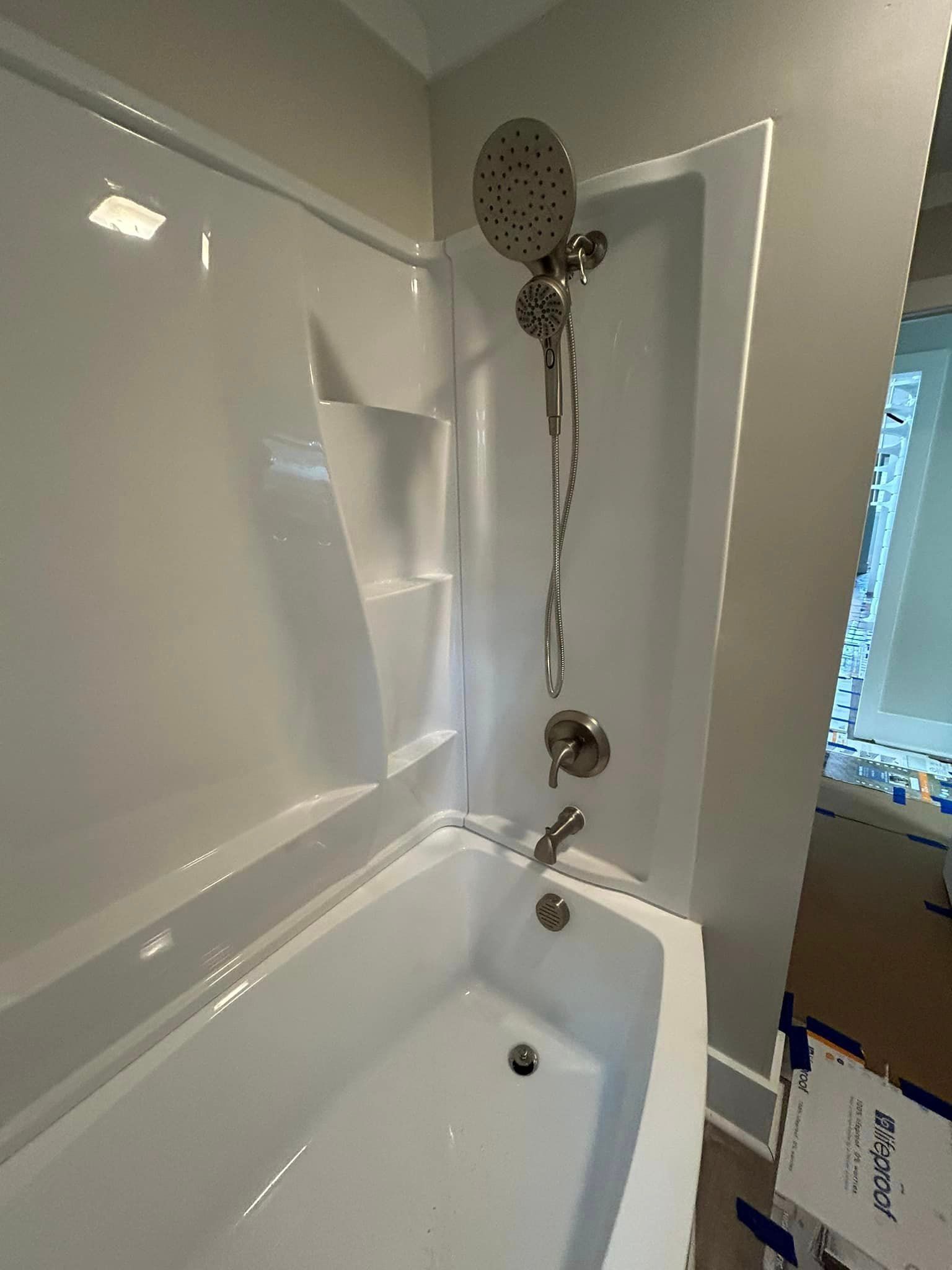 A bathroom with a bathtub and a shower head.