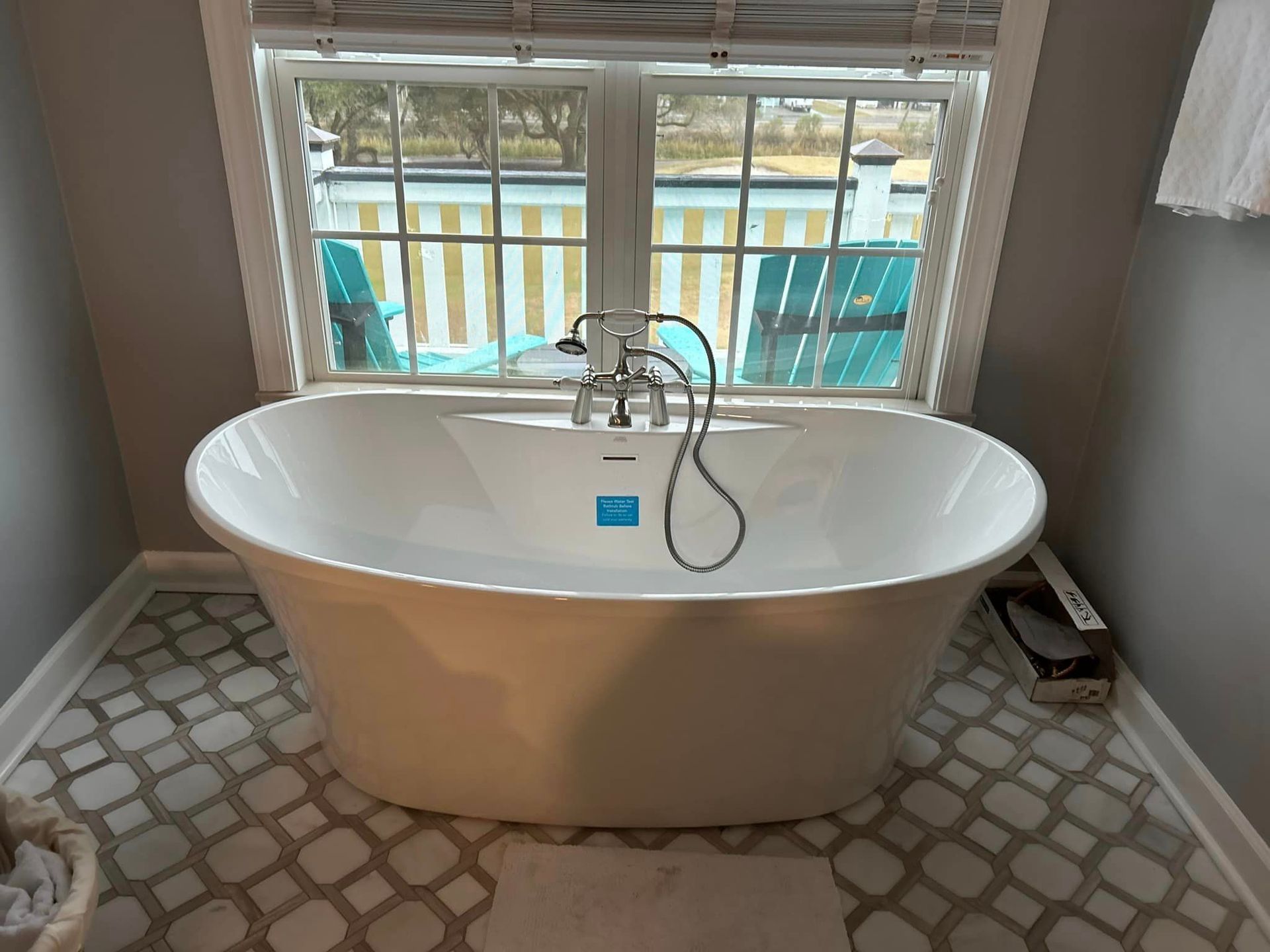 A bathtub is sitting in a bathroom next to a window.