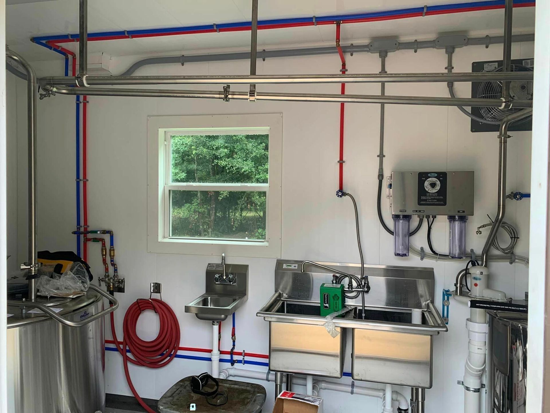 A kitchen with stainless steel sinks and a window