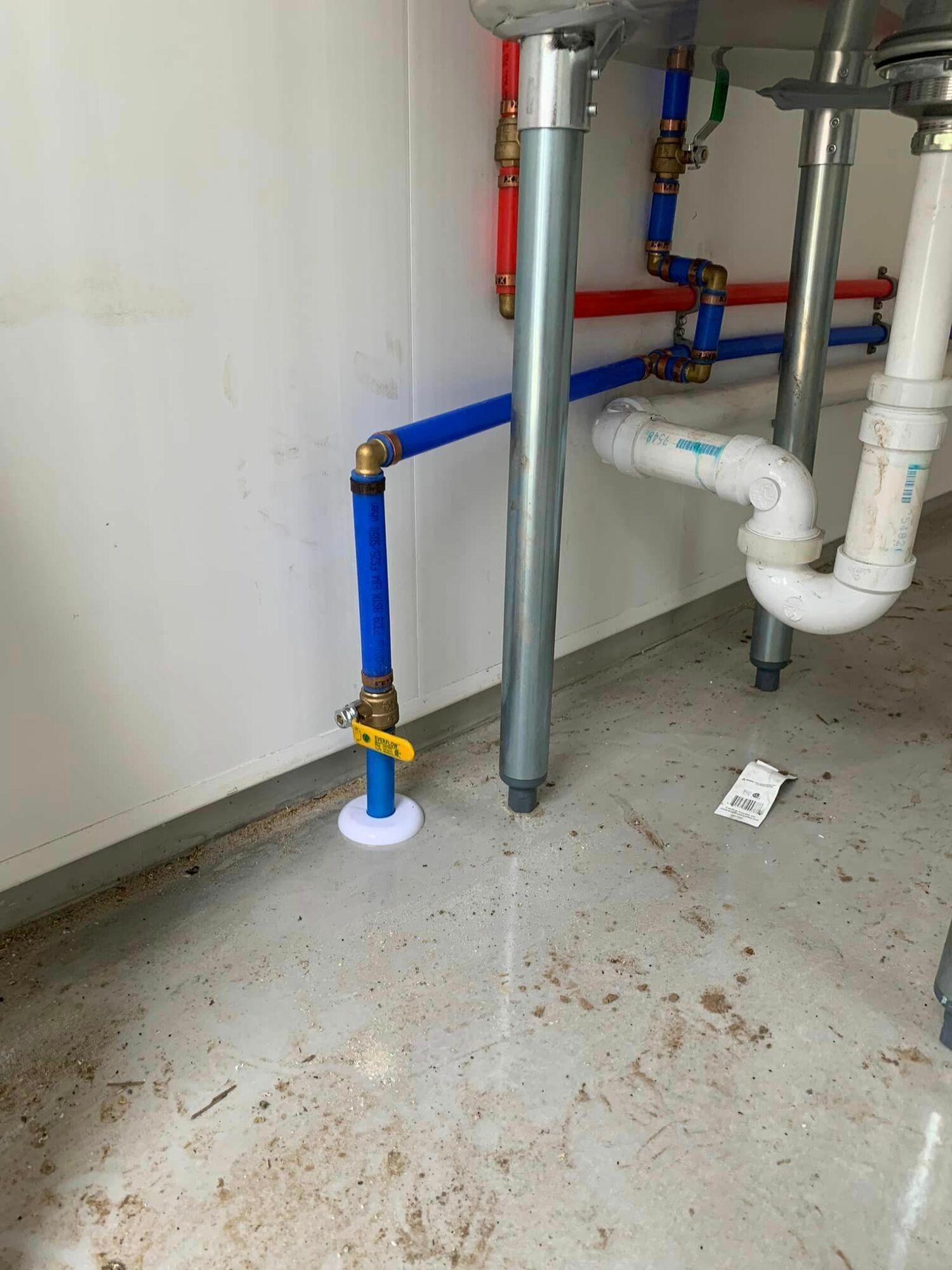 A bathroom sink with a lot of pipes underneath it.