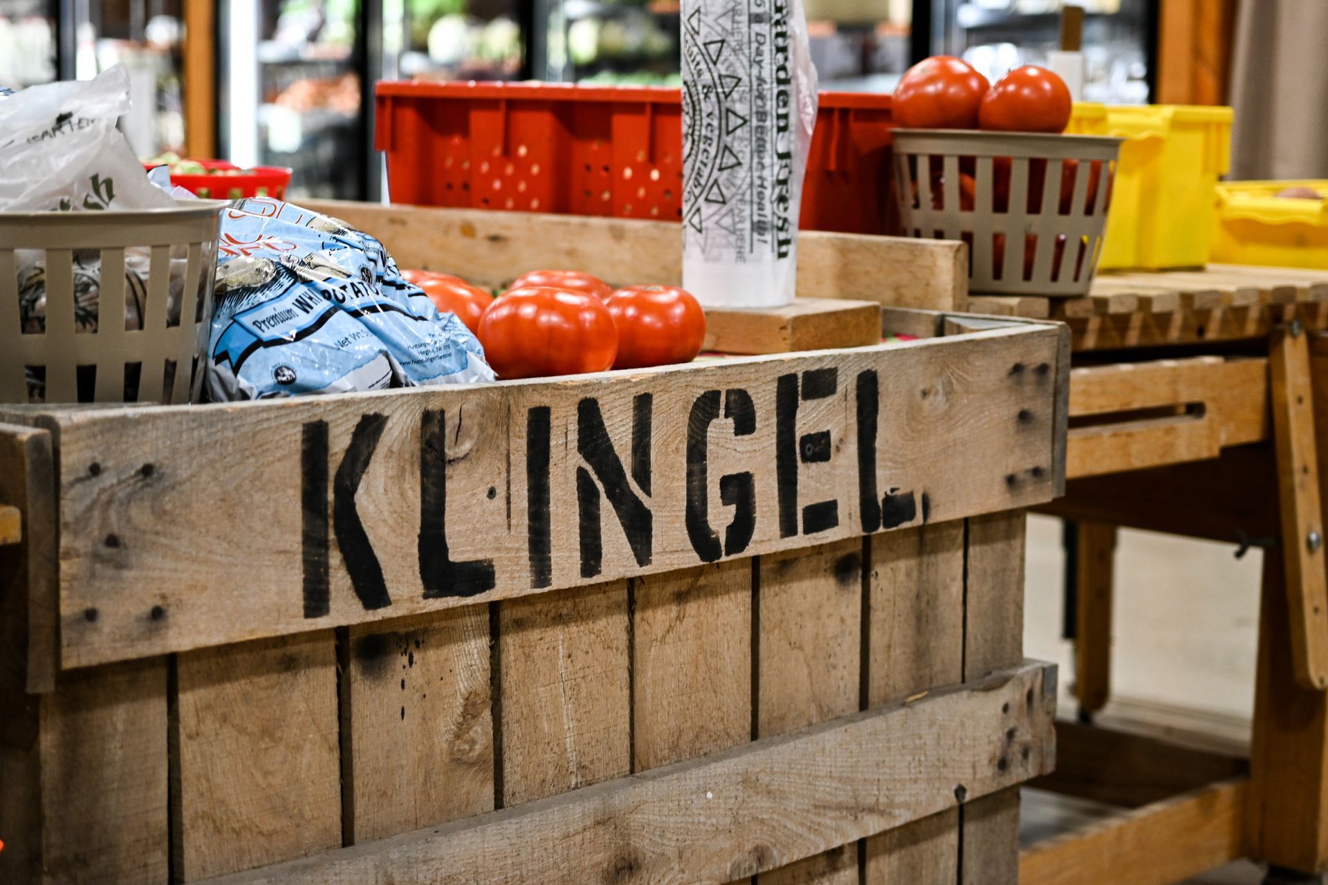 A wooden crate filled with tomatoes and a sign that says klingel.