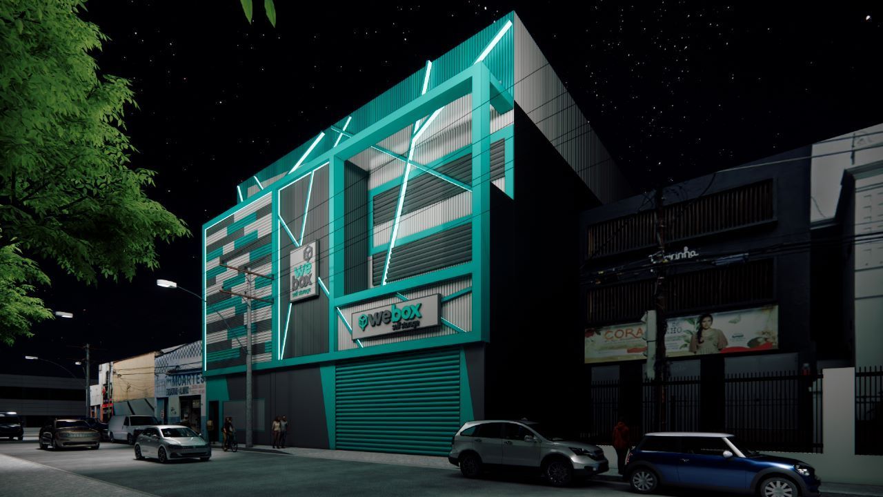 We Box Self Storage Uma representação de um prédio à noite com carros estacionados em frente a ele.