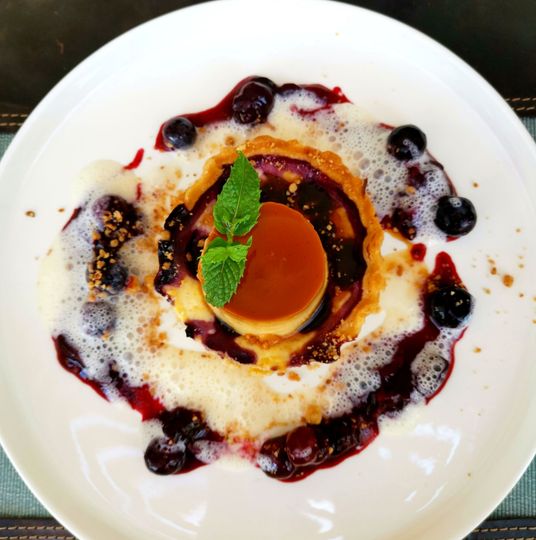 Ein weißer Teller mit einem Dessert und Blaubeeren