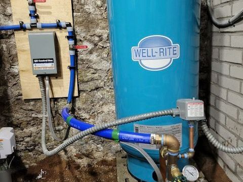 A blue water tank is sitting on a counter next to a hose.