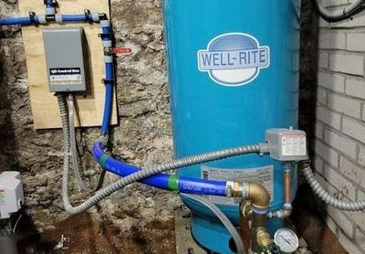 A blue water tank is sitting on a counter next to a hose.