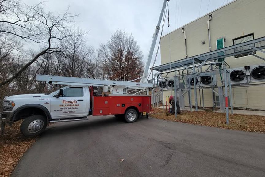 A red and white truck is parked in front of a building.