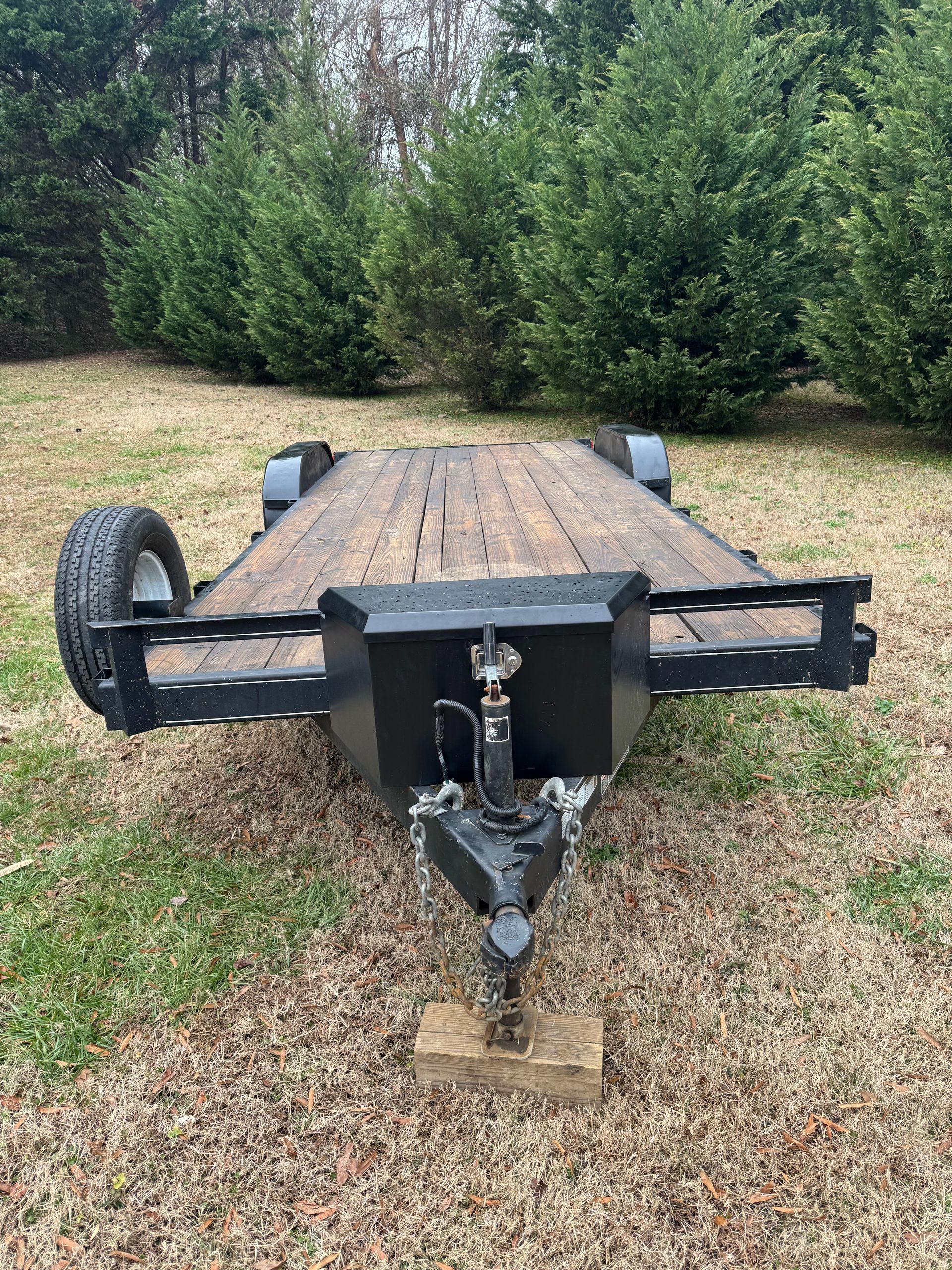 A flatbed trailer is parked in a grassy field.