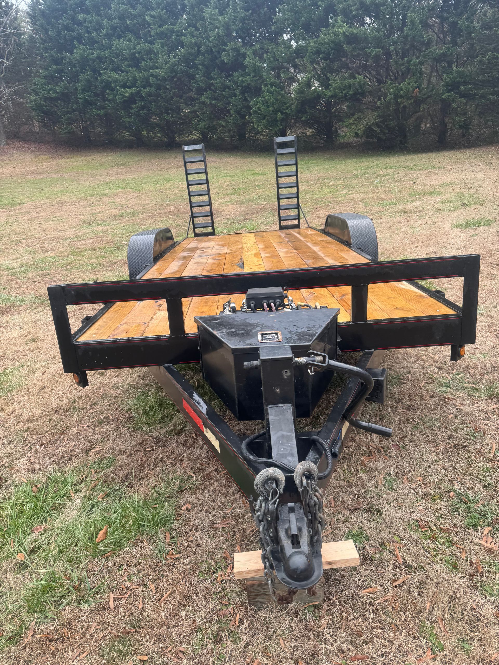 A trailer is sitting on top of a dirt field.