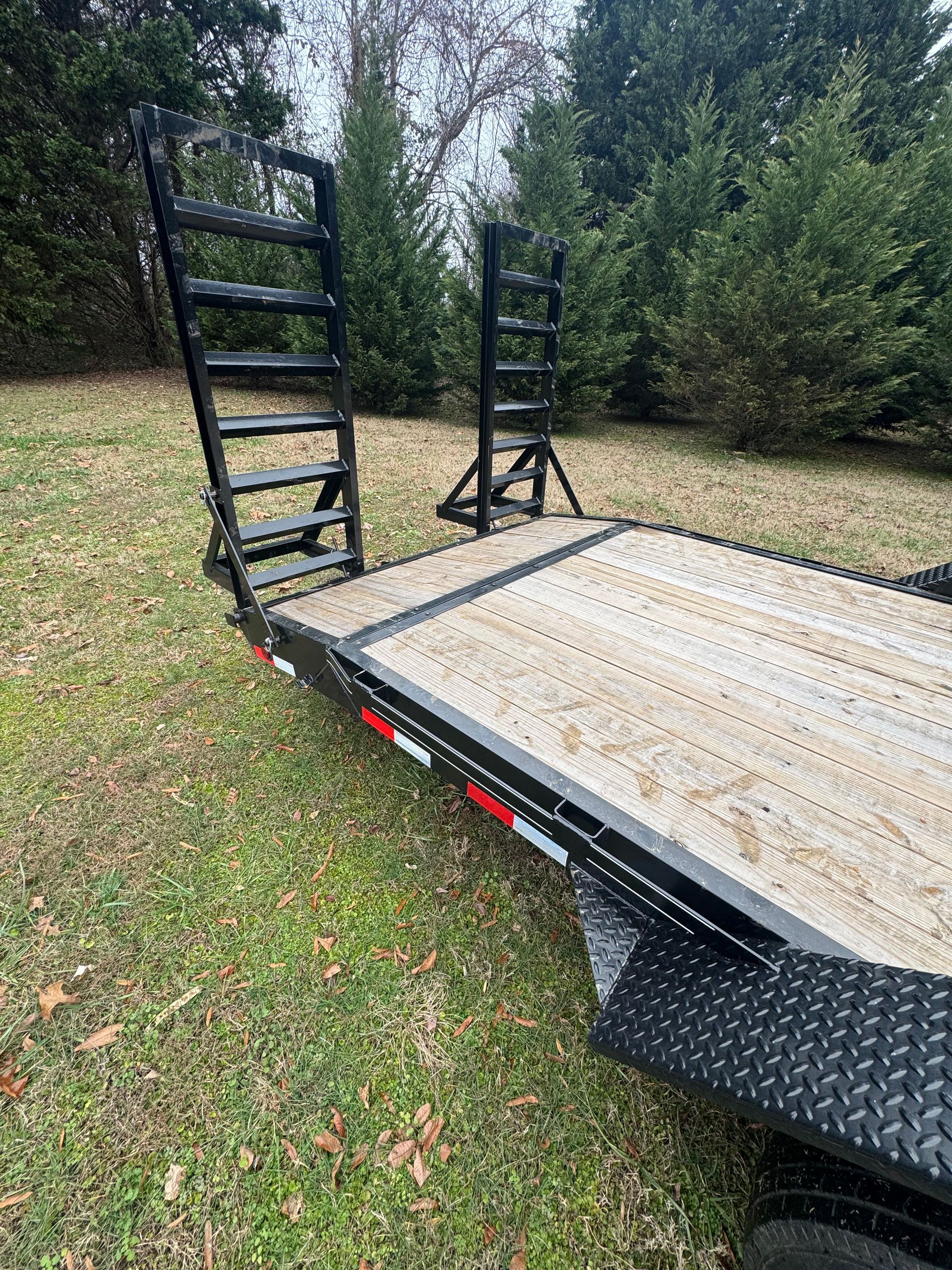 A trailer with stairs attached to it is parked in a grassy field.