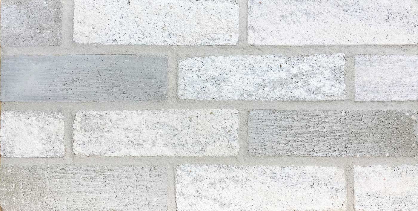 White and gray brick wall with textured surface and visible mortar.