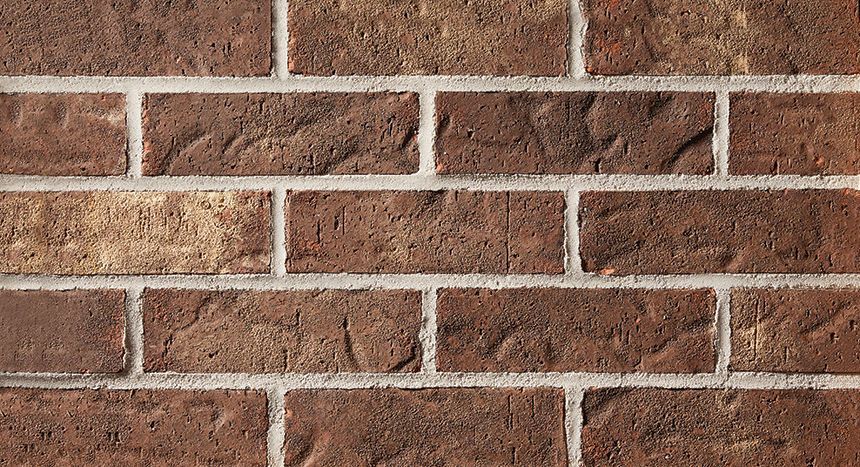 Brick wall with reddish-brown bricks and white mortar.