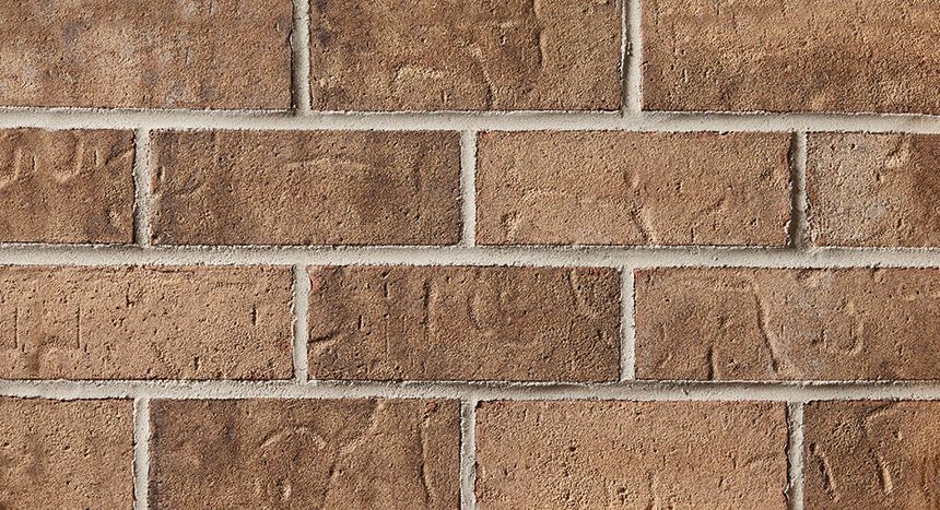 Brown brick wall with light-colored mortar between the bricks.