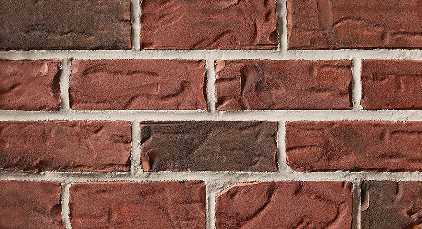 Red and brown brick wall with white mortar.