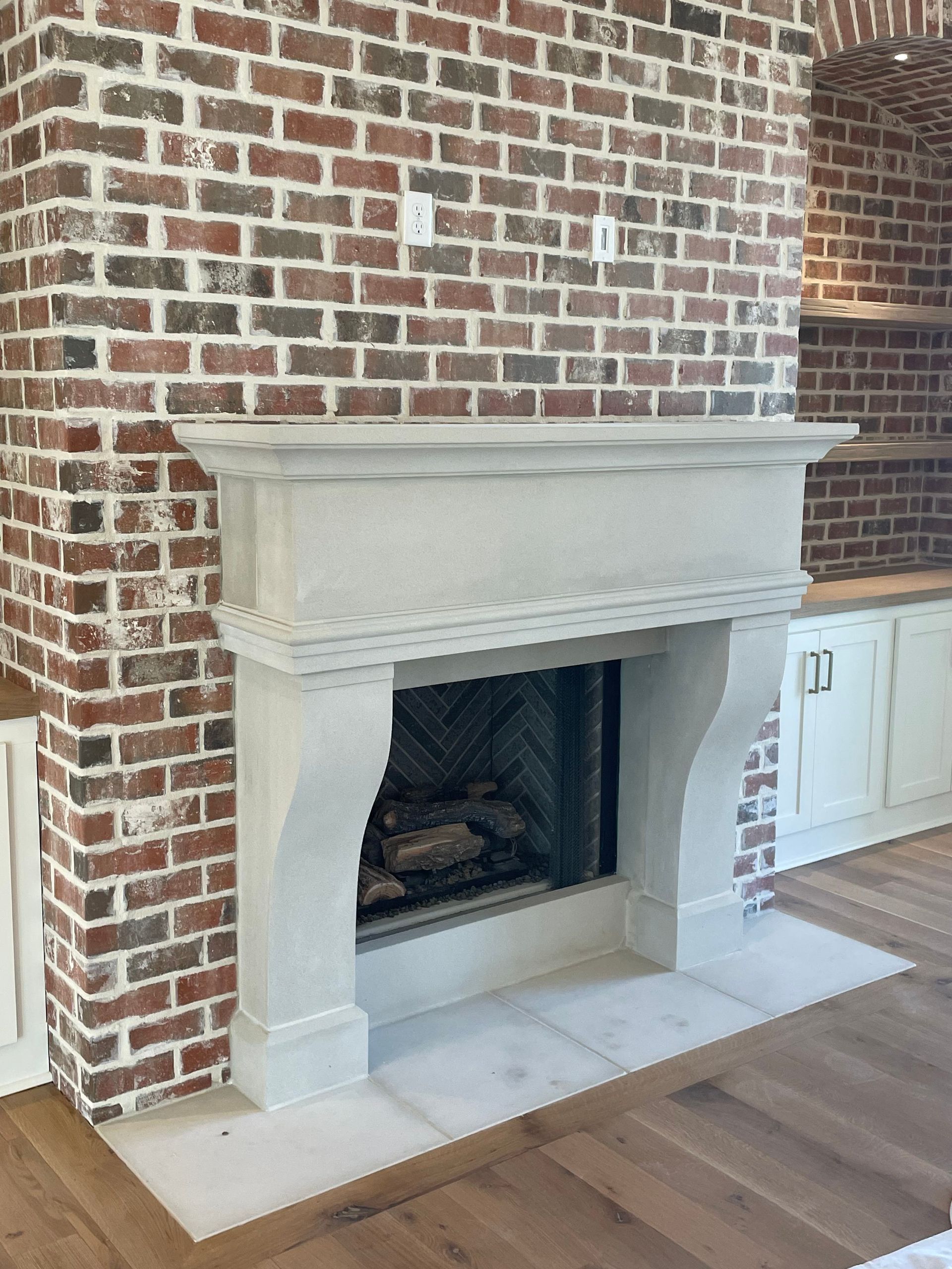 Brick fireplace with a stone mantel and hearth.