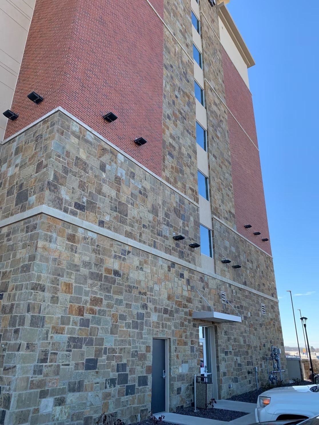 A tall brick and stone building with a blue sky background.