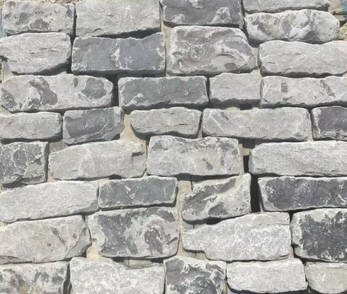 Stone wall built with gray and dark gray rectangular blocks.