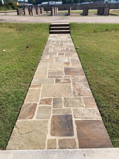 Stone pathway leading to steps and a park structure.