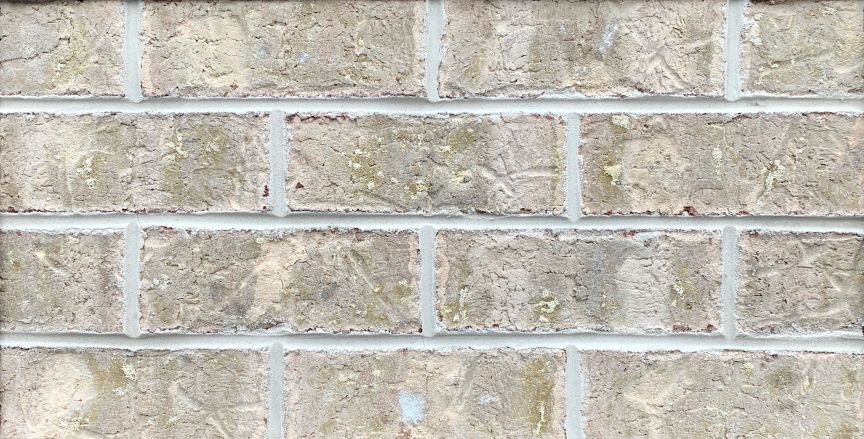 Close-up of a brick wall with light gray bricks and white mortar.