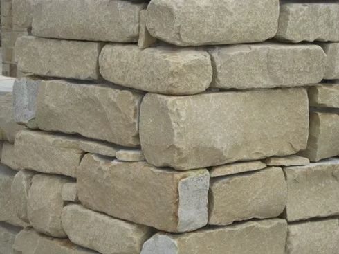 Stacked rectangular beige stone blocks forming a corner.