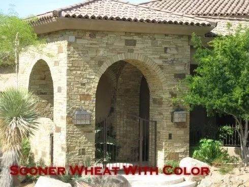 Stone arched entryway with a gated entrance and a tiled roof.