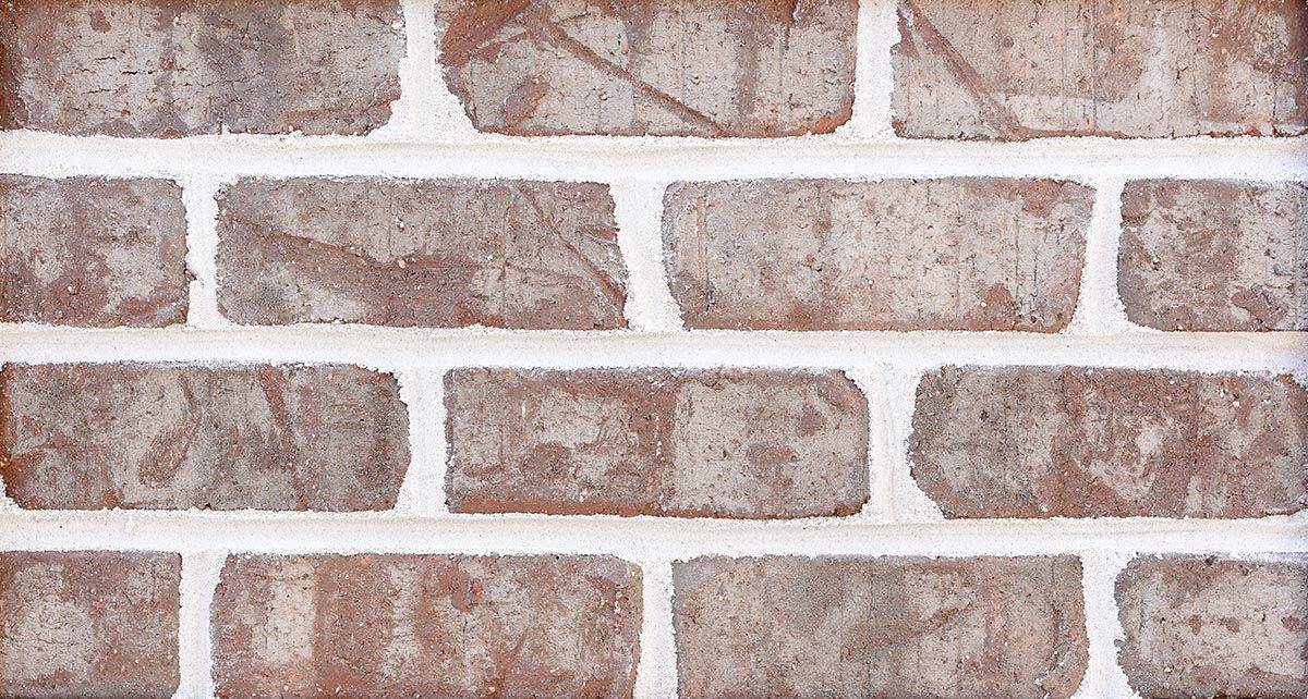 Brick wall with brown bricks and white mortar.