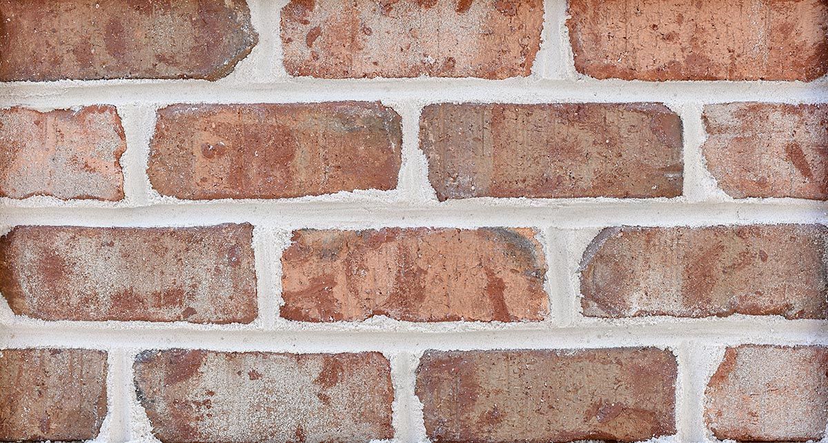 Red and tan brick wall with white mortar.
