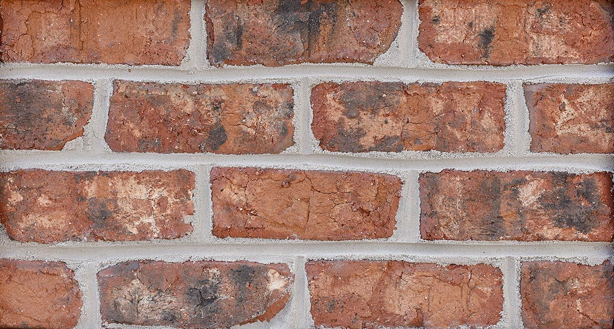 Red brick wall with gray mortar.
