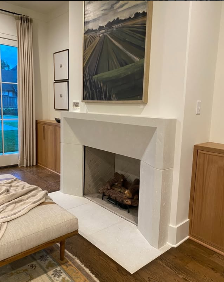 Fireplace with artwork and wooden cabinets in a living room.