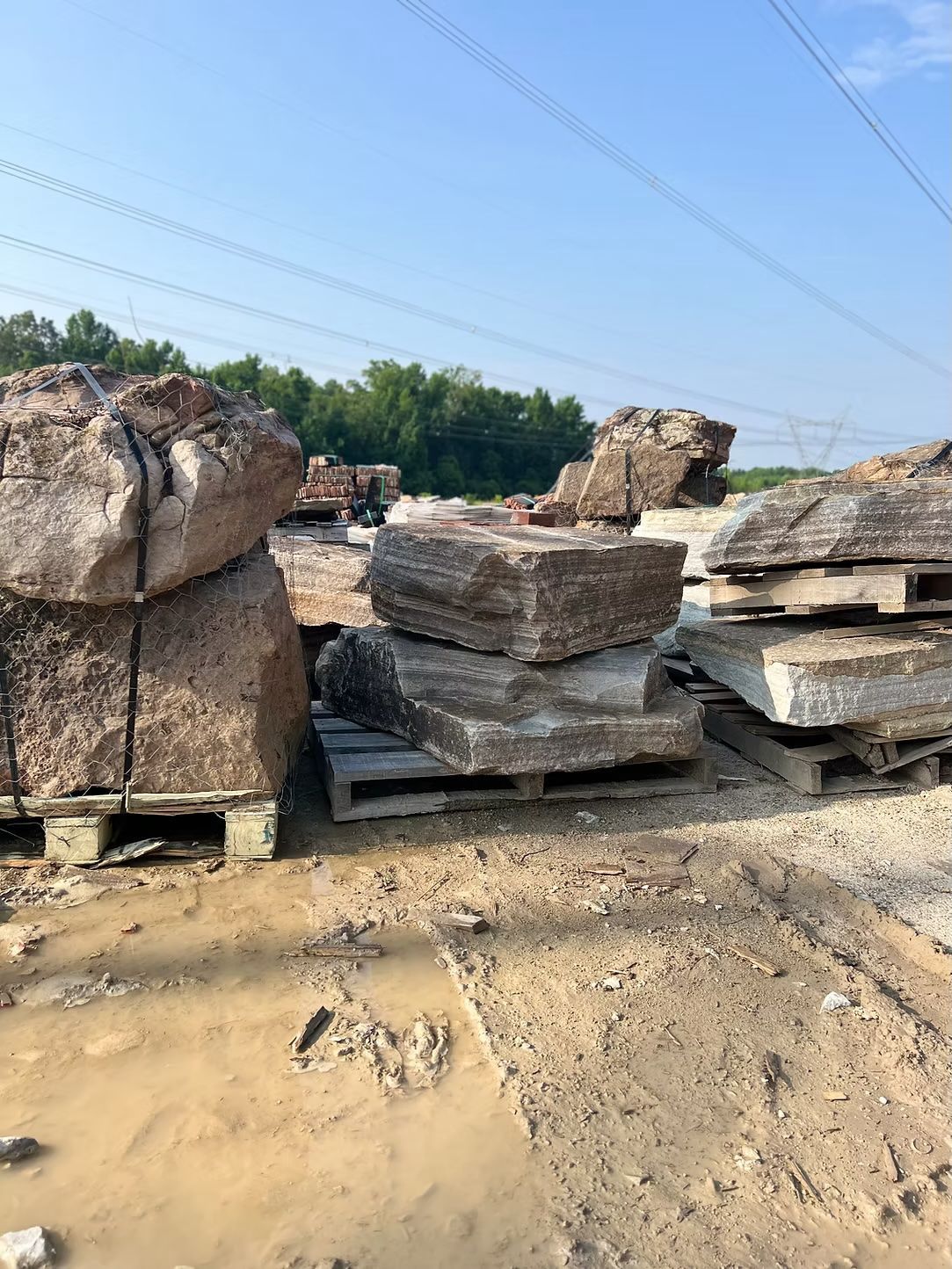 Large stone slabs stacked on pallets outdoors, likely for construction or landscaping.