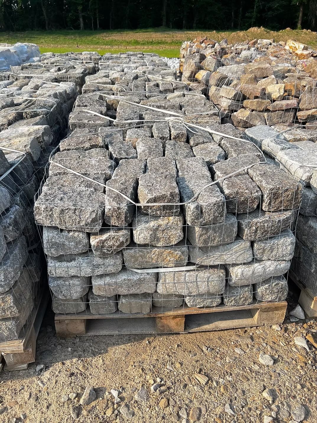 Pallets of gray, square cobblestones, bound with wire.