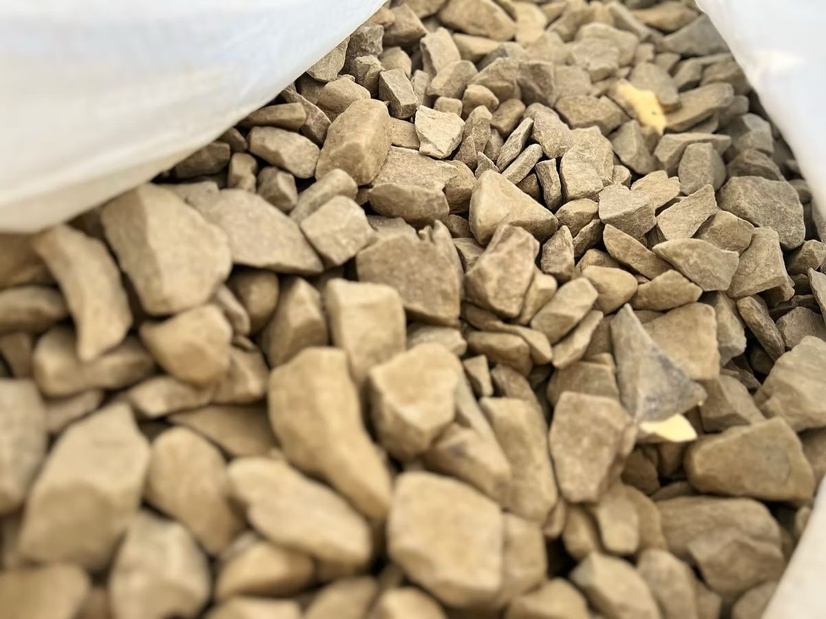 Tan-colored, irregularly shaped rocks filling a white bag.