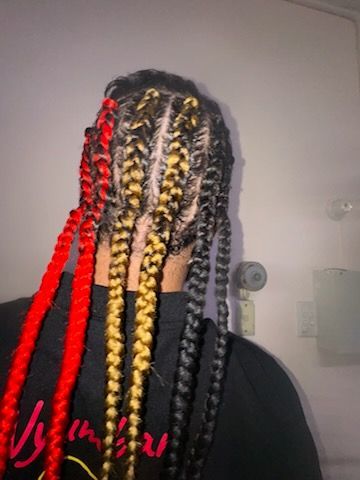 A woman with red and yellow braids is wearing a black shirt.