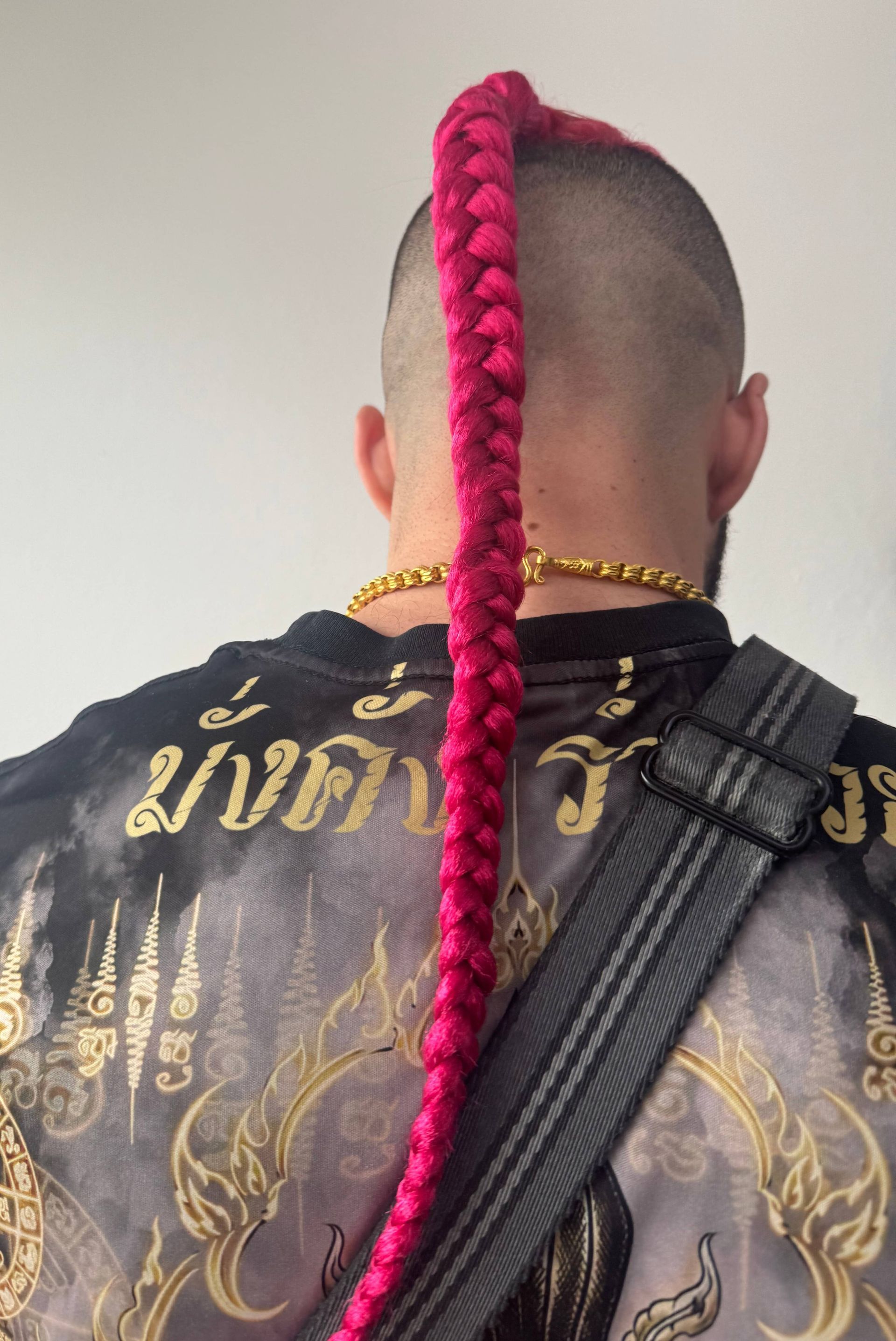 A man with a braided mohawk wearing a black shirt