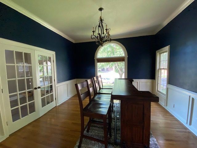 A dining room with a table and chairs and a chandelier