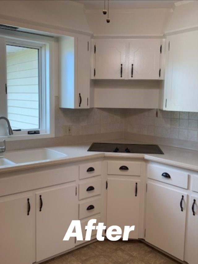 A kitchen with white cabinets and black handles and the words after on the bottom
