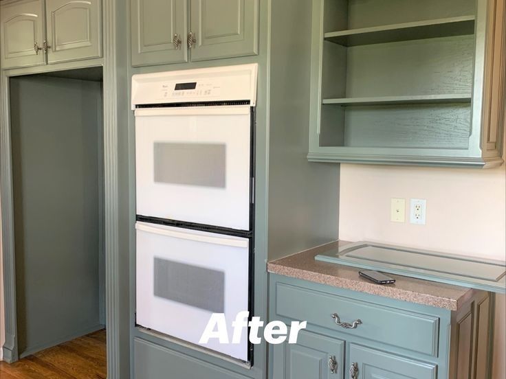 A kitchen with blue cabinets and white appliances after being painted.