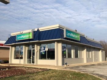 A bank with a blue roof and a green sign that says land nation