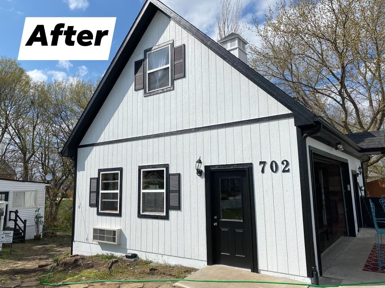 A white house with black trim and shutters has been painted black and white.