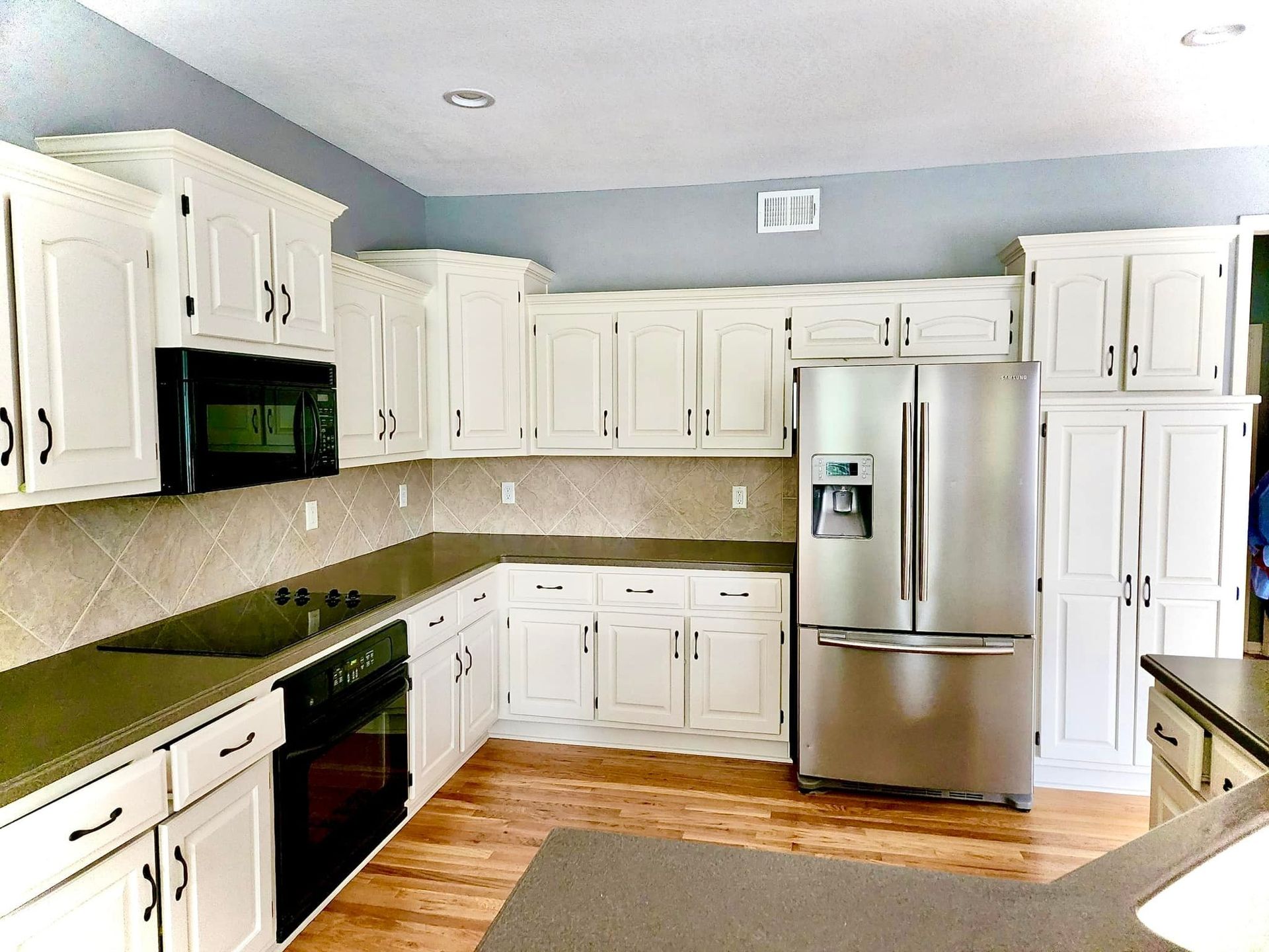 A kitchen with white cabinets and stainless steel appliances