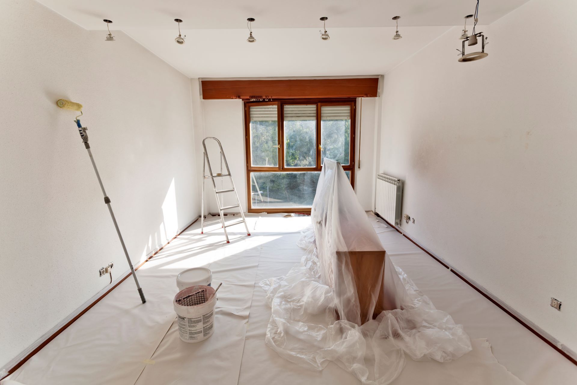 A room is being painted with a roller and ladder.