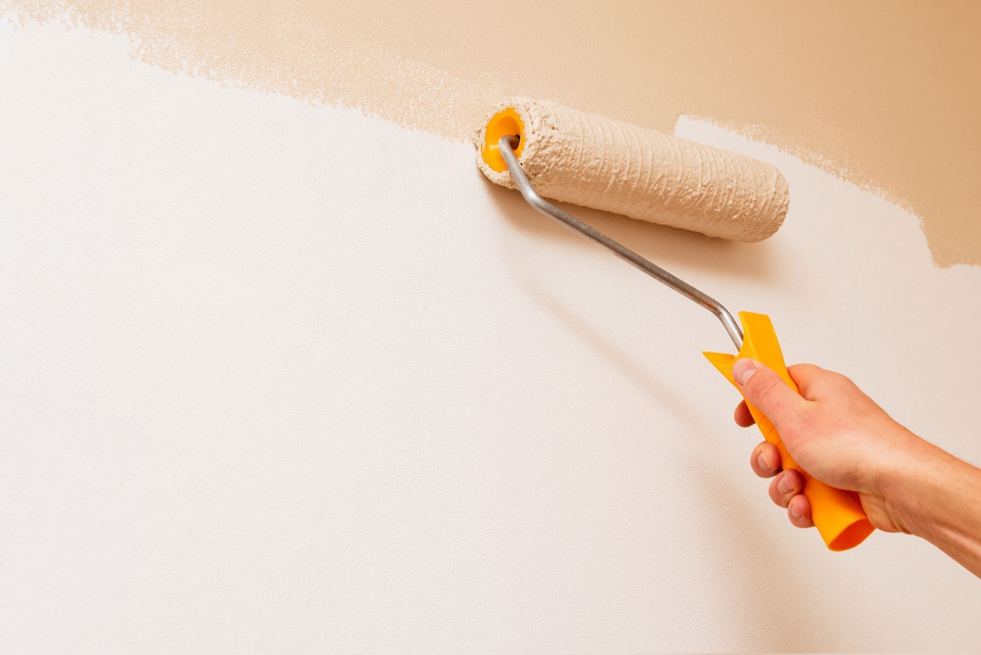 paint roller painting a wall in home